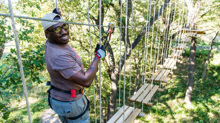 People navigate the Go Ape Treetop Adventure ropes course at Eugene T. Mahoney State Park in Cass County. The course is part of the Nebraska game and Parks Commission's Venture Parks initiave. Fowler, Sept. 23, 2018. Copyright NEBRASKAland Magazine, Nebraska Game and Parks Commission.