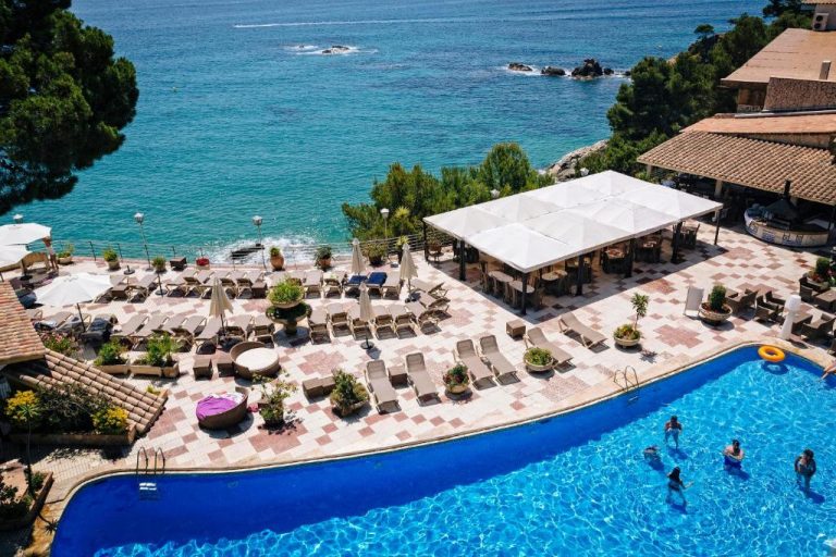 Piscina exterior con tumbonas y terraza del Hotel Cap Roig & Spa by Brava Hoteles con vistas al mar