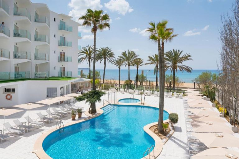 Piscina exterior con tumbonas y palmeras del HSM Golden Playa con vistas al mar y la playa