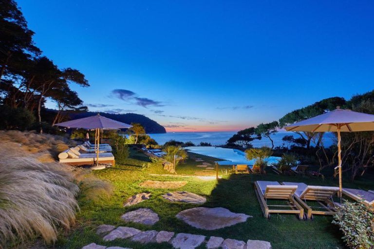Piscina infinita con tumbonas y vistas al mar al atardecer en Pleta de Mar Grand Luxury Hotel