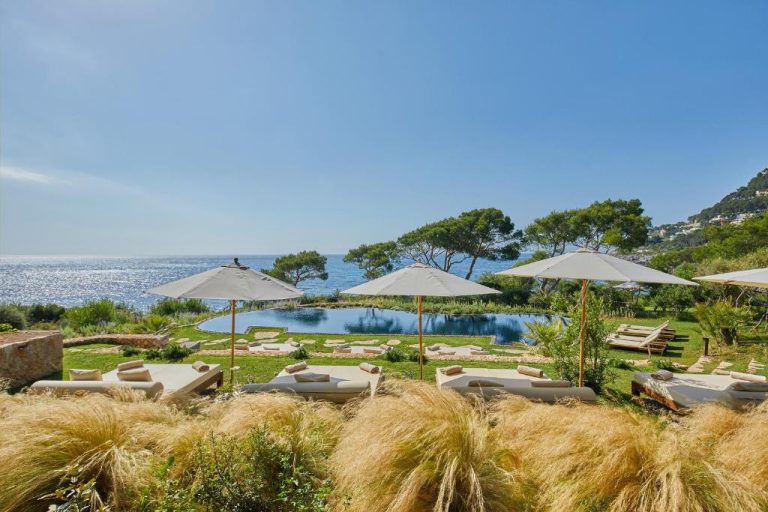 Piscina exterior con tumbonas y sombrillas del Pleta de Mar Grand Luxury Hotel con vistas al mar de Mallorca