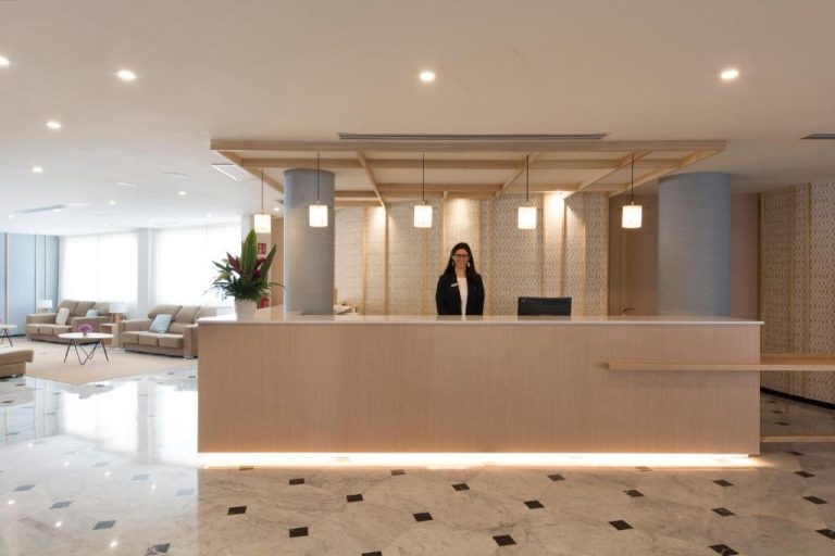 Recepción moderna e iluminada del HSM Golden Playa con suelo de mármol y personal de atención al cliente