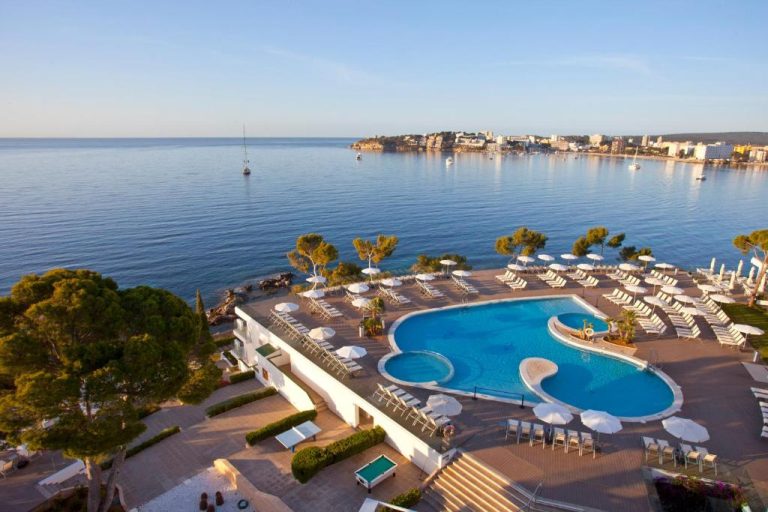 Piscina exterior con tumbonas y sombrillas del Aparthotel Ponent Mar con vistas al mar en Mallorca