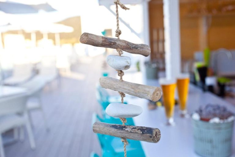 Decoración náutica con palos de madera y piedras en la terraza del Aparthotel Ponent Mar