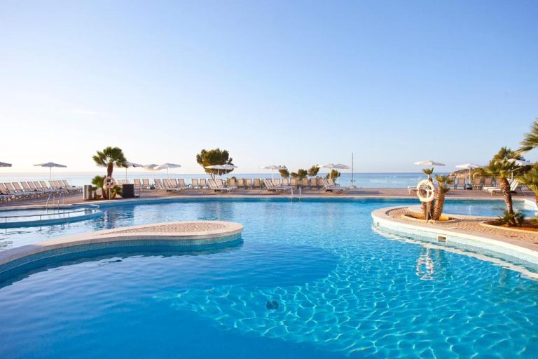Piscina exterior con tumbonas y sombrillas del Aparthotel Ponent Mar con vistas al mar Mediterráneo