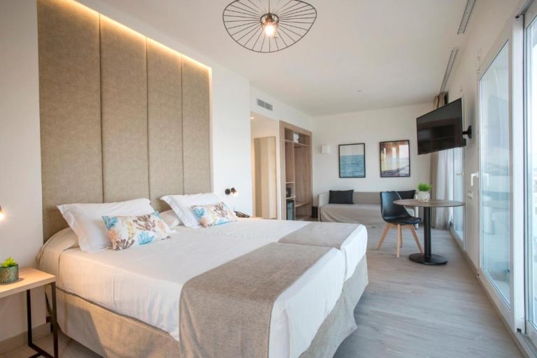 Habitación doble superior con cama king size y zona de estar en Hotel Las Arenas