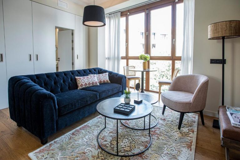 Elegante salón con sofá azul Chester y mesa de centro en suite del Palma Suites