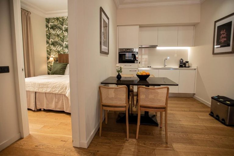Suite con cocina equipada y comedor en Palma Suites, con dormitorio de fondo decorado