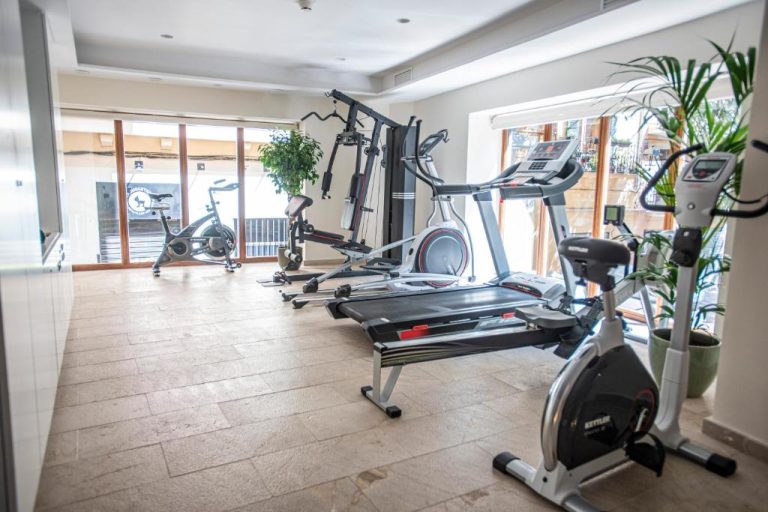 Gimnasio completamente equipado con cintas de correr y bicicletas estáticas en Palma Suites