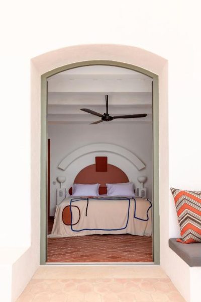 Habitación doble con arco decorativo y ventilador de techo en Menorca Experimental Hotel
