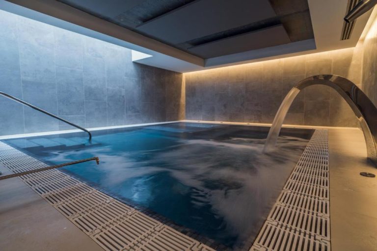 Piscina interior con cascada de agua y zona spa del Catalonia Gran Vía Bilbao