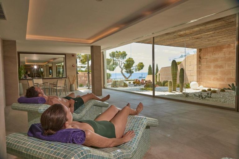 Zona de relax con tumbonas de mosaico y vistas al jardín de cactus en el spa del Aparthotel Ponent Mar