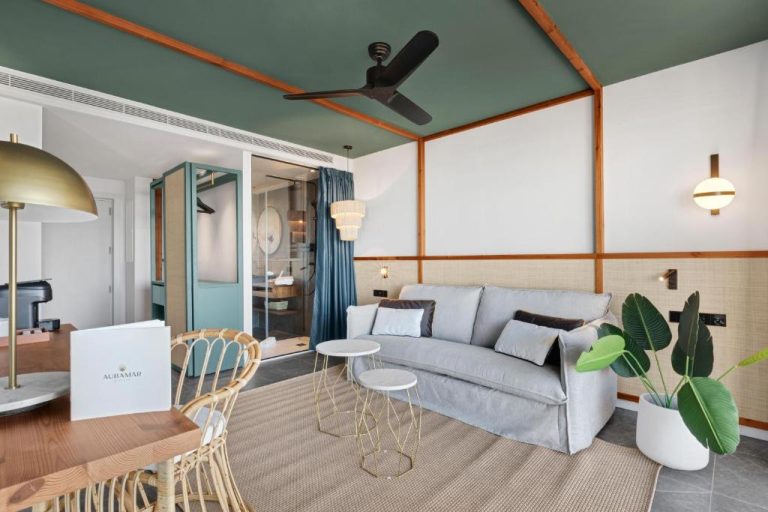 Salón moderno con sofá gris y decoración tropical en suite del Aubamar Palma Resort