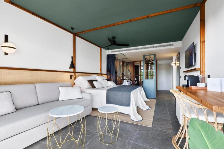 Suite con sofá, cama doble y zona de estar moderna en el Aubamar Palma Resort