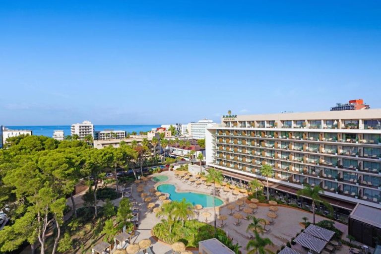 Vista aérea de la piscina exterior con hamacas y palmeras del Aubamar Palma Resort