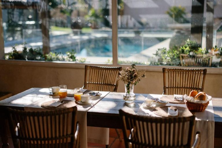 Desayuno con zumo y pan en terraza con vistas a la piscina del Hotel Finca El Peregrino