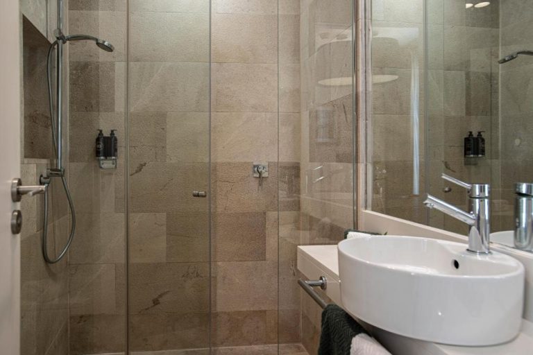 Baño moderno con ducha de mármol y lavabo empotrado en Palma Suites