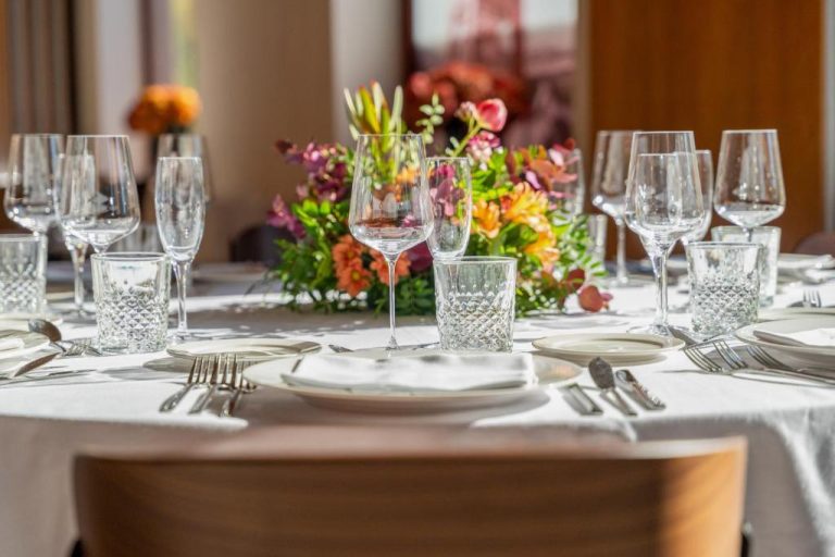 Mesa de gala elegantemente decorada con cristalería y flores en el salón de eventos del Hotel Meliá Bilbao