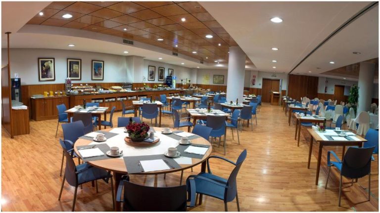 Amplio restaurante con buffet y mesas preparadas para el desayuno en el Extremadura Hotel