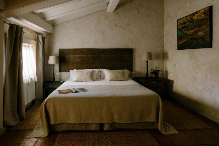 Habitación doble rústica con cama king size y cabecero de madera en Hotel Finca El Peregrino