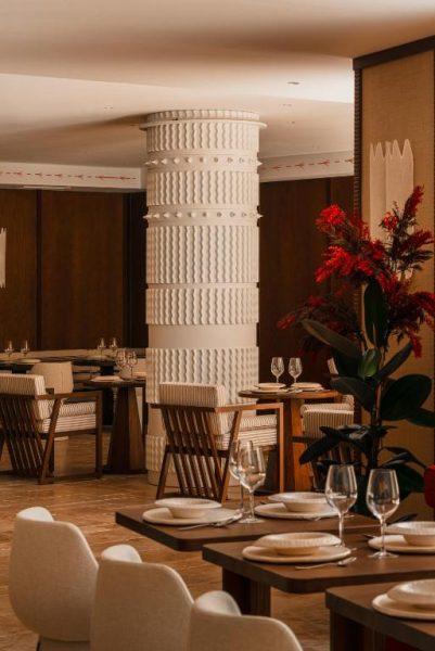 Elegante restaurante del Palacio de Godoy Cáceres Curio Collection by Hilton con mesas y columna decorativa blanca