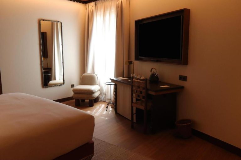 Habitación elegante con televisión de pantalla plana y escritorio en Palacio de Godoy Cáceres Hilton