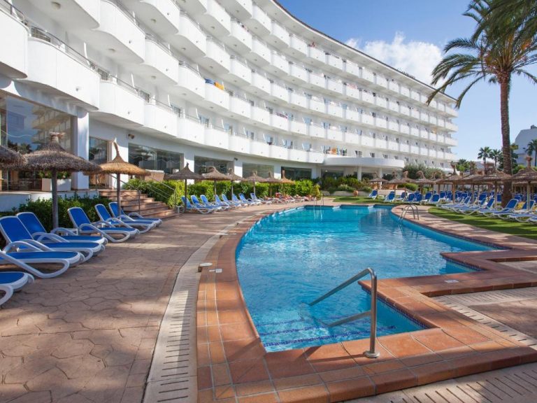 Piscina exterior con tumbonas azules y sombrillas del Grupotel Maritimo en Mallorca