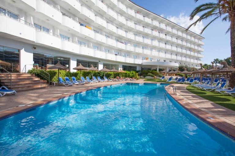 Piscina exterior con tumbonas azules y sombrillas del Grupotel Maritimo en Mallorca