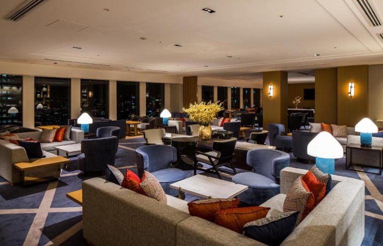 Elegante salón lounge con sofás y vistas nocturnas de Tokio en Keio Plaza Hotel Tokyo Premier Grand