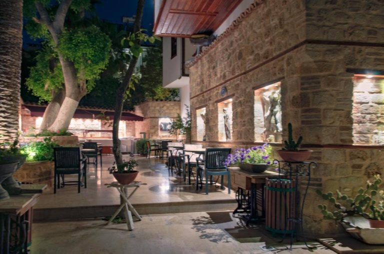 Terraza exterior iluminada con mesas y jardín del White Garden Hotel Adult Only en Bodrum