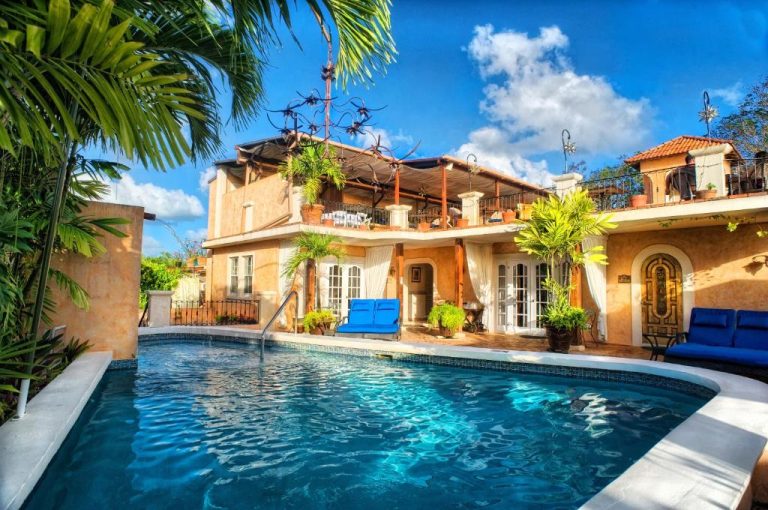 Piscina exterior con tumbonas azules y villa colonial del Little Arches Boutique Hotel Adults Only en Barbados