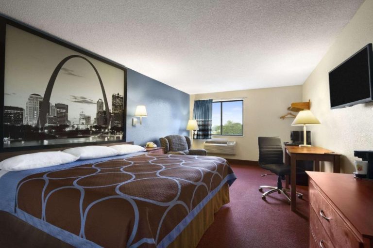 Habitación con cama king size y mural del Arco Gateway en Super 8 by Wyndham Cuba