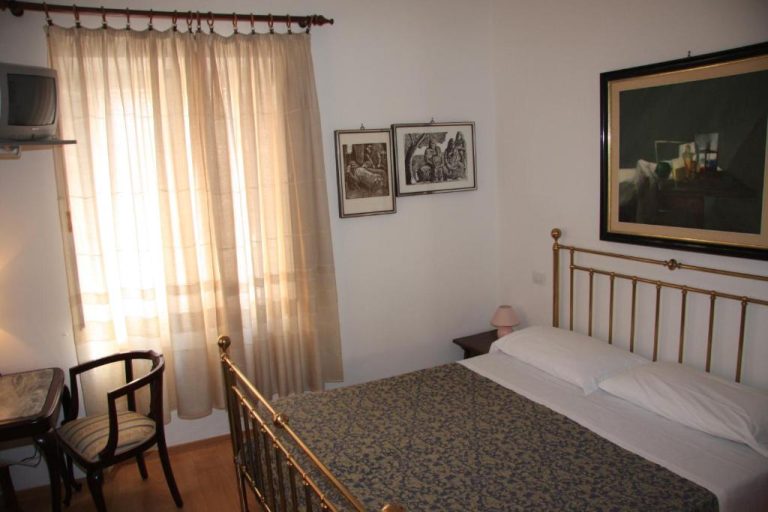 Habitación doble con cama de bronce y decoración clásica en el Hotel Morlacchi