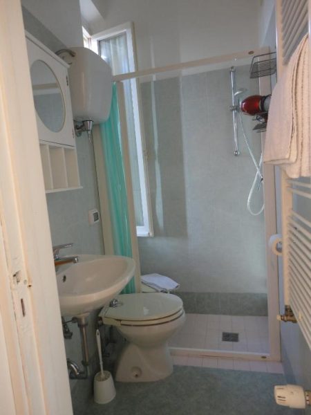 Baño completo con ducha, lavabo y aseo del Hotel Morlacchi, decorado en tonos verdes