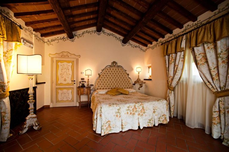 Habitación doble de lujo con cabecero vintage y techo de vigas en Relais La Corte dei Papi