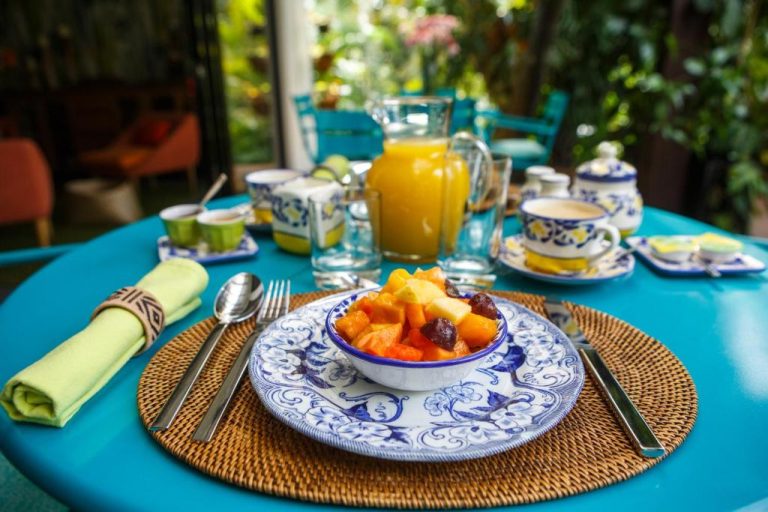 Desayuno con ensalada de frutas tropicales y jugo de naranja en el Hotel Patio del Mundo