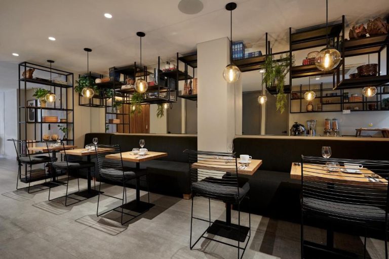 Restaurante interior del 14 Urban Hotel con mesas de madera, sillas metálicas y decoración industrial moderna