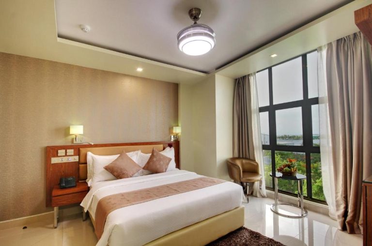 Habitación doble con cama king size y amplia ventana con vistas al exterior en Unima Grand