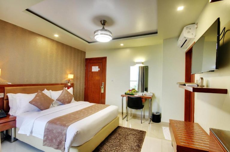 Habitación doble con cama king, escritorio y televisión del Unima Grand Hotel