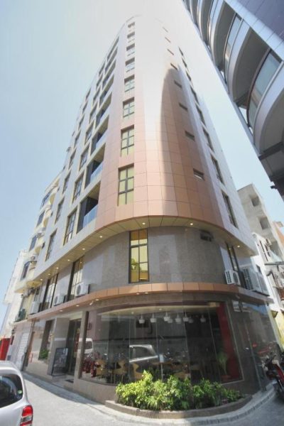 Fachada exterior del Hotel Unima Grand, moderno edificio de varios pisos con acabados en cobre y cristal
