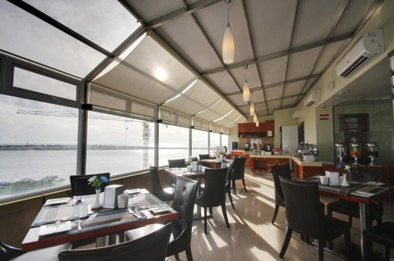 Restaurante con vista panorámica al mar del Unima Grand Hotel, mesas elegantes y techo acristalado