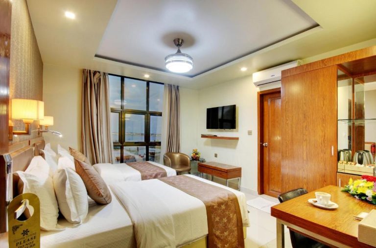 Habitación doble con dos camas y vista al mar en el Hotel Unima Grand, decoración moderna en tonos cálidos