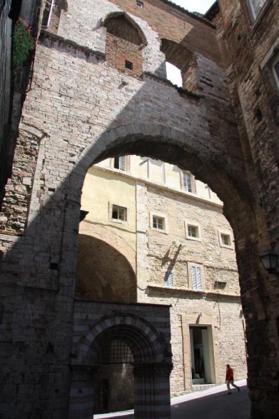 Imponente arco medieval de piedra en los alrededores del Hotel Morlacchi en Perugia, Italia