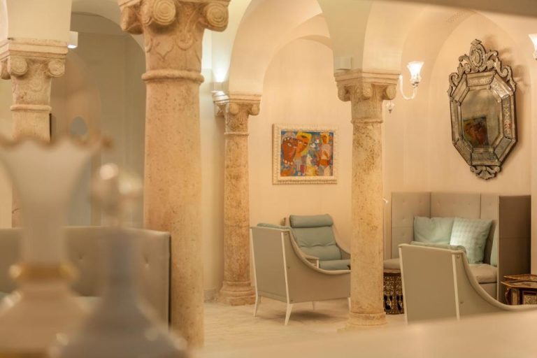 Elegante lobby con columnas de mármol y sillones del Dar El Jeld Hotel and Spa en Túnez