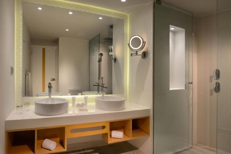Baño doble con lavabos redondos y ducha de cristal en Catalonia Riviera Maya Resort & Spa