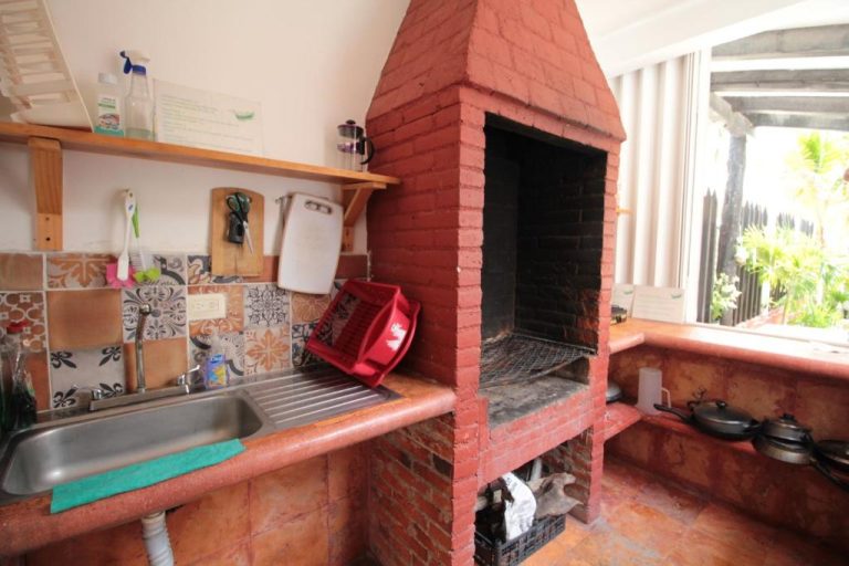 Cocina exterior con barbacoa de ladrillo rojo y fregadero en Villas Roseliz