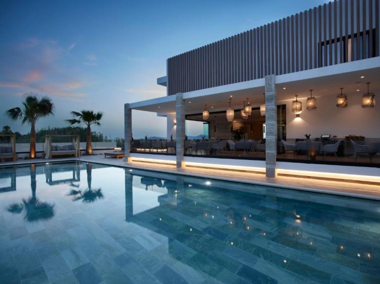 Piscina exterior iluminada al atardecer con restaurante terraza en Lango Design Hotel & Spa Adults Only