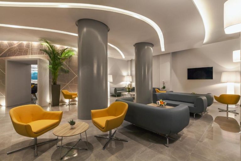 Lobby moderno con sillones amarillos y sofás grises en el Blue Lagoon City Hotel