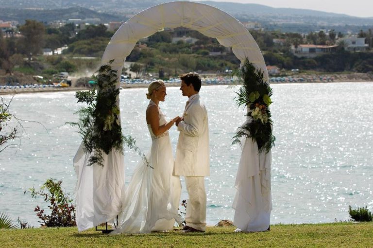 Ceremonia de boda frente al mar en Thalassa Boutique Hotel & Spa con arco floral blanco