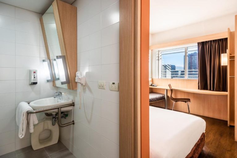 Baño adaptado con lavabo accesible y habitación con escritorio en el hotel ibis Bogotá Museo